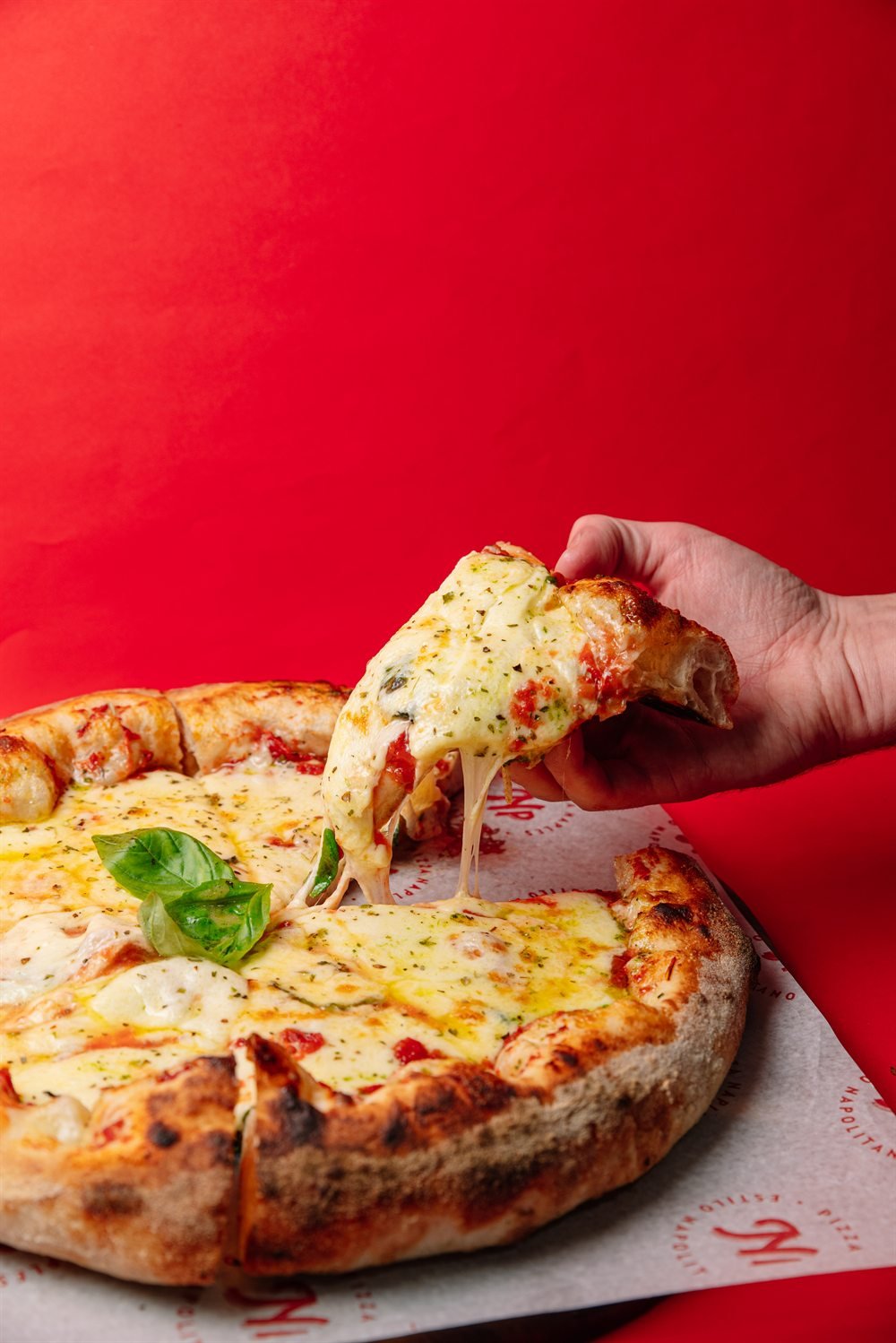Pizza Margherita Naples con cheese pull sobre papel NP - estilo napolitano